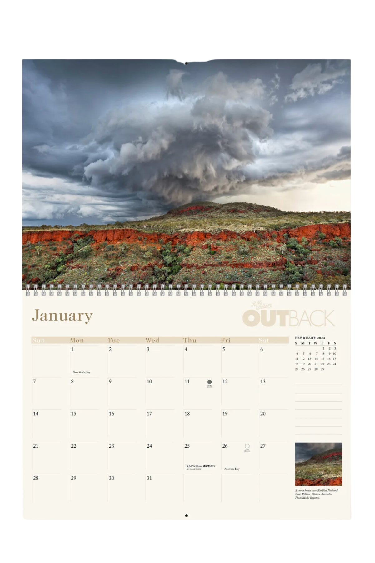 The RM Williams Outback Calendar 2024 showcases a stunning storm cloud over a red dirt landscape by a leading Australian rural photographer. It includes day squares for planning and a mini February calendar, with "Outback" tastefully integrated into the design.
