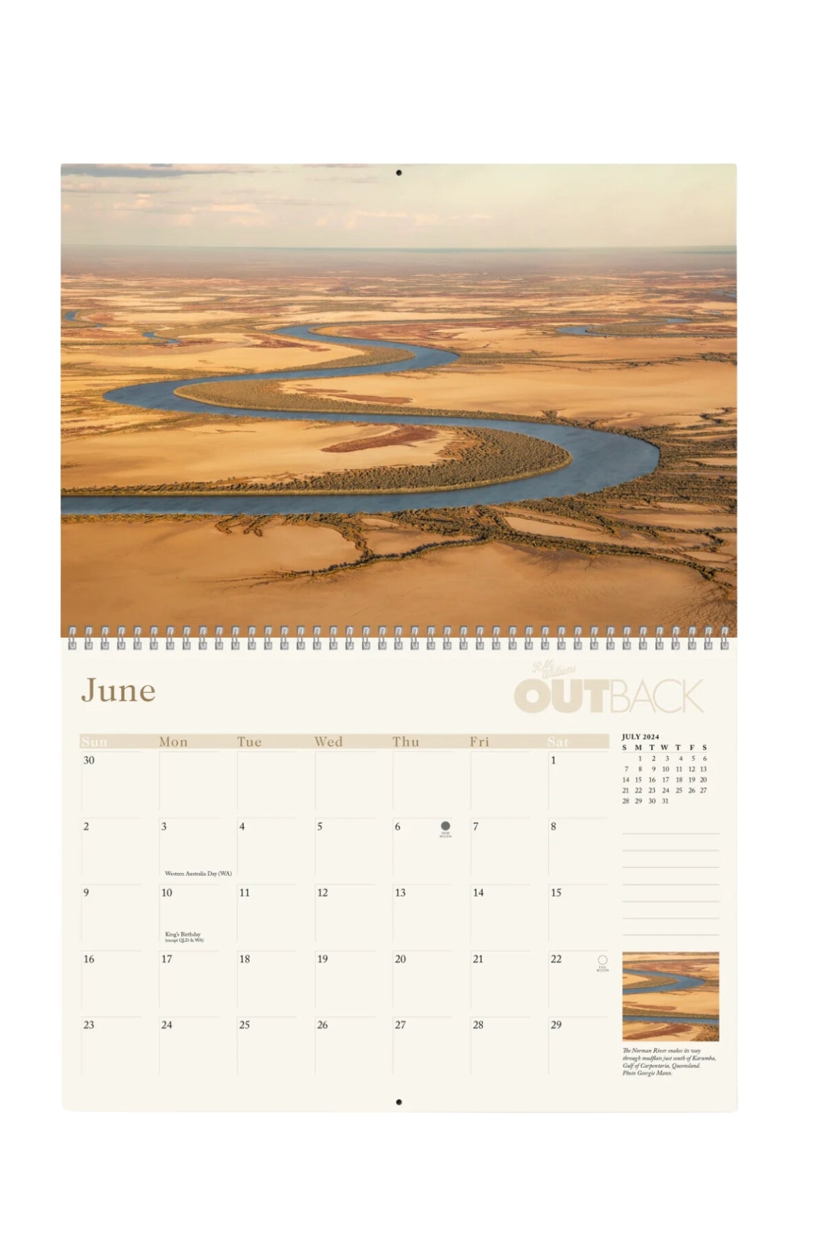 The June page of the RM Williams Outback Calendar 2024 features an aerial photo by leading Australian rural photographers, showcasing a winding river through a dry landscape. A monthly grid below and "OUTBACK" in the top right complete the layout.