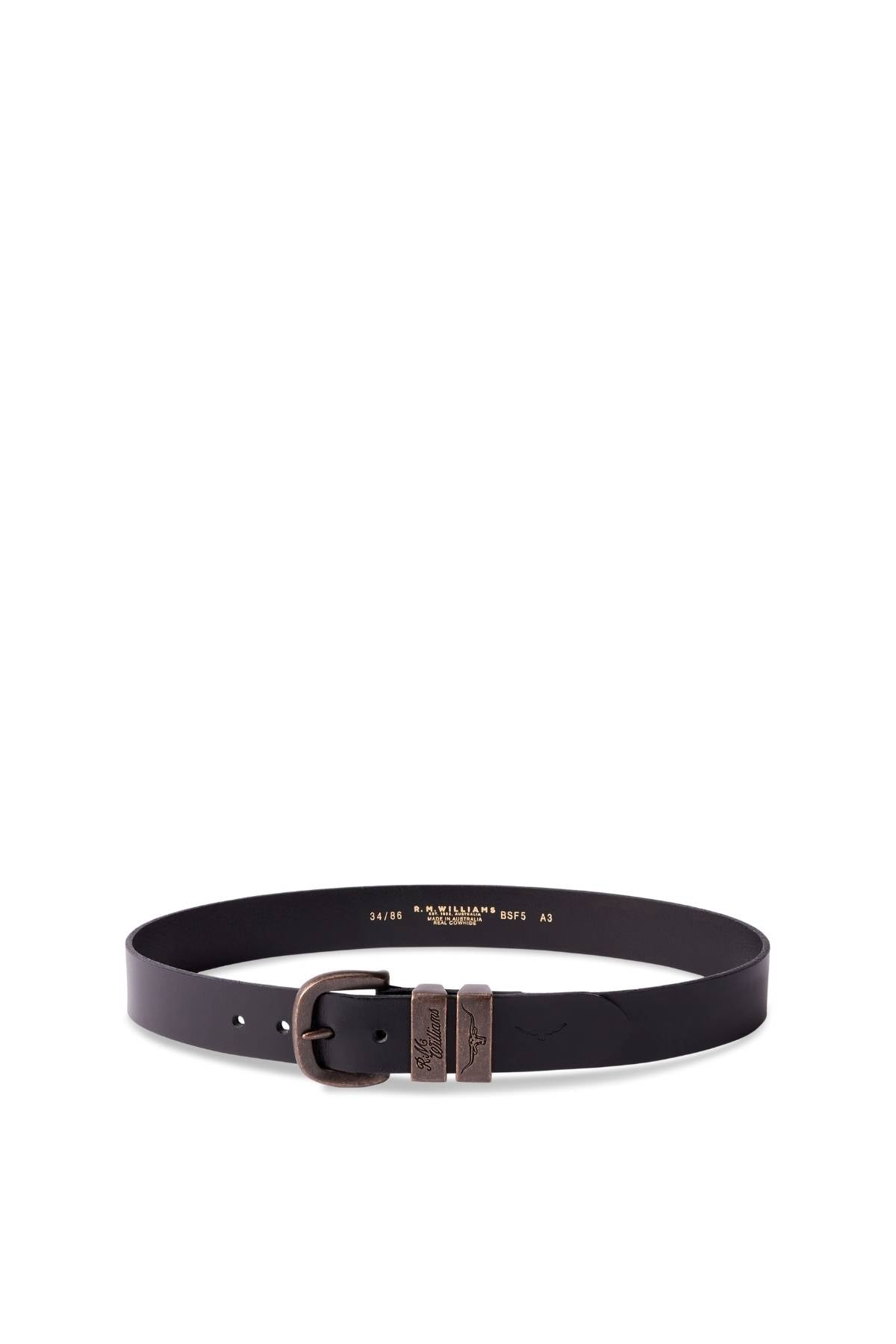 The RM Williams Drover Belt is a black pull-up leather belt with a bronze metal buckle, two decorative metal accents, and classic double keepers, displayed in a circular shape on a white background.