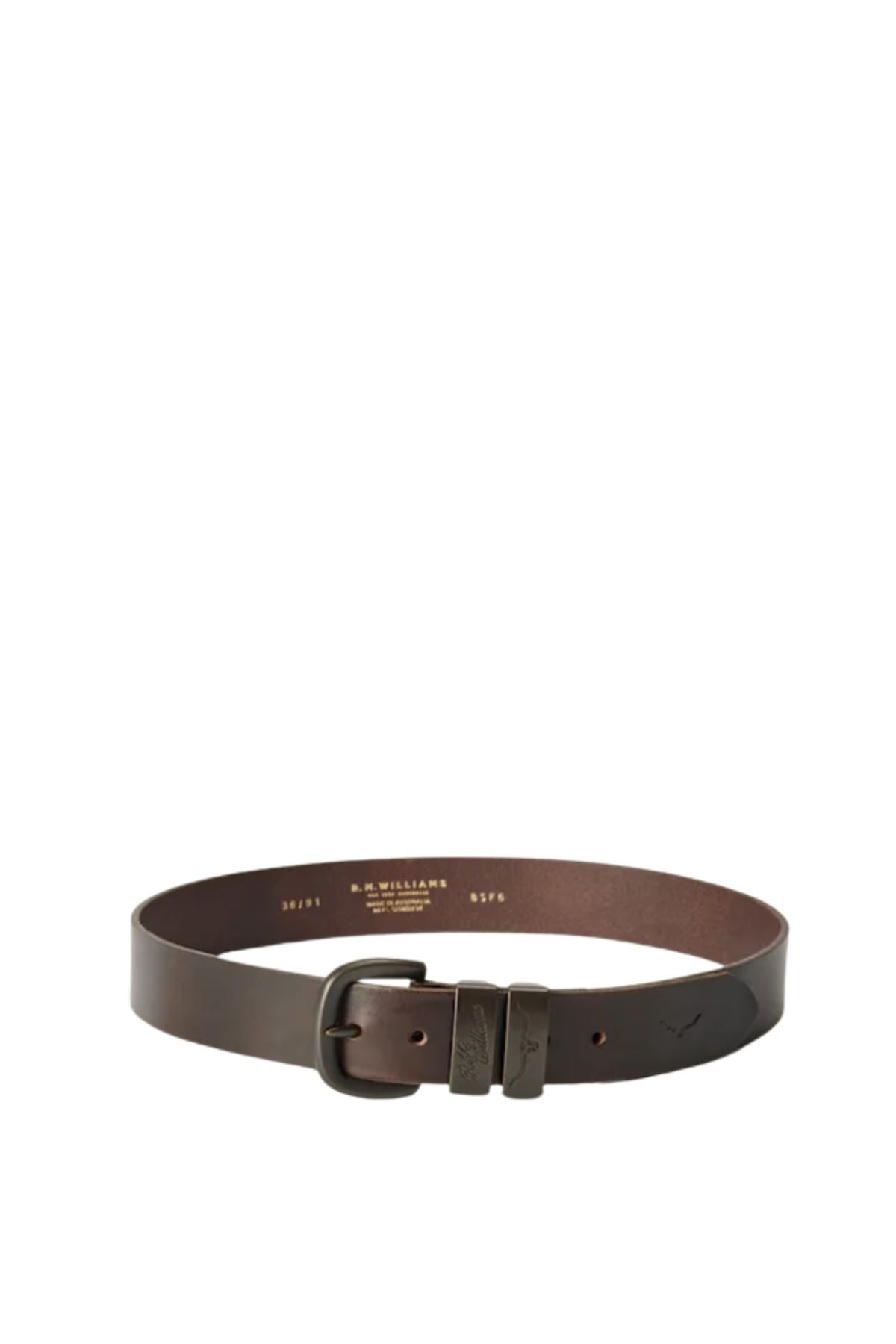 The RM Williams Drover Belt, in dark brown vegetable-tanned leather, features a matte black buckle and embossed detailing near the buckle, shown arranged in a circular shape.