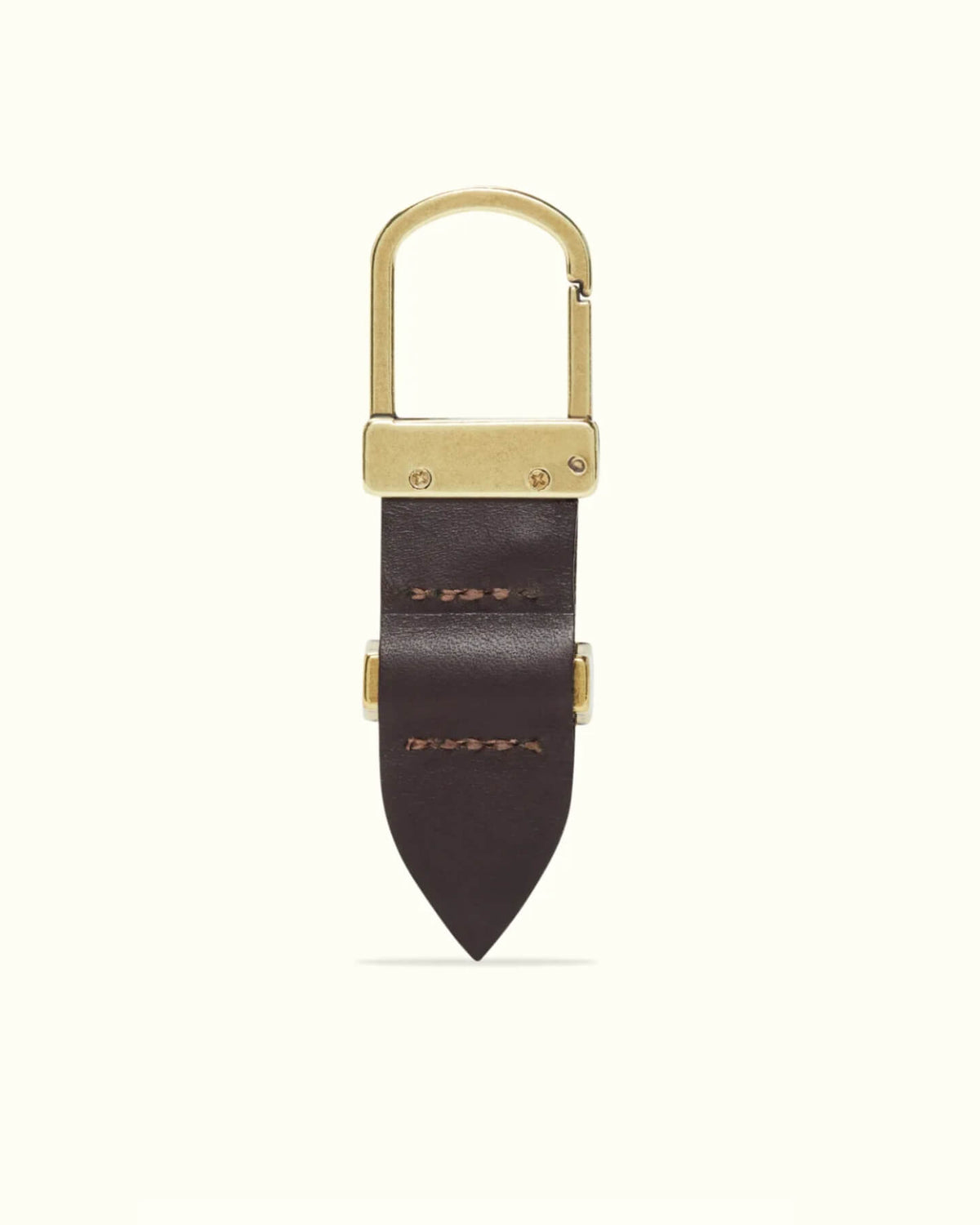 The RM Williams Drover Key Fob is a gold carabiner-style keychain with a dark brown, double butt leather design and two stitches on its pointed end. Antique brass hardware elegantly joins the metal and leather components against a plain light background.