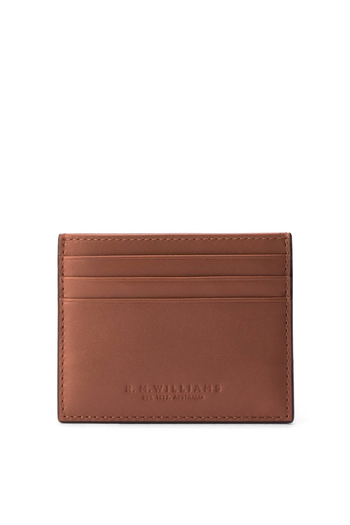 The RM Williams Farrier Cardholder features brown full grain leather, four card slots, subtle stitching, and "R.M.Williams Est. 1932 Australia" embossed on the front in a sleek, minimalist design.