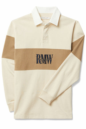 The RM Williams Heritage Rugby is a long-sleeve organic cotton shirt in cream and tan, featuring a white collar, horizontal tan chest stripe, and an embroidered "RMW" Heritage logo.