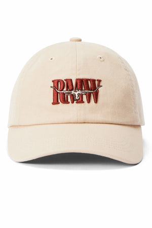 The RM Williams Heritage Twill Cap is a beige organic cotton cap with a red embroidered "RMW" heritage logo accented by a barbed wire design. It includes an adjustable strap for comfort.