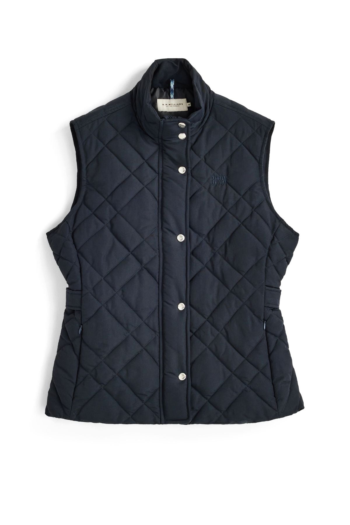 The RM Williams Ikara Vest, a sleeveless navy blue quilted vest made from recycled nylon, features silver snap buttons and a stand-up collar and is displayed laid flat on a white background.