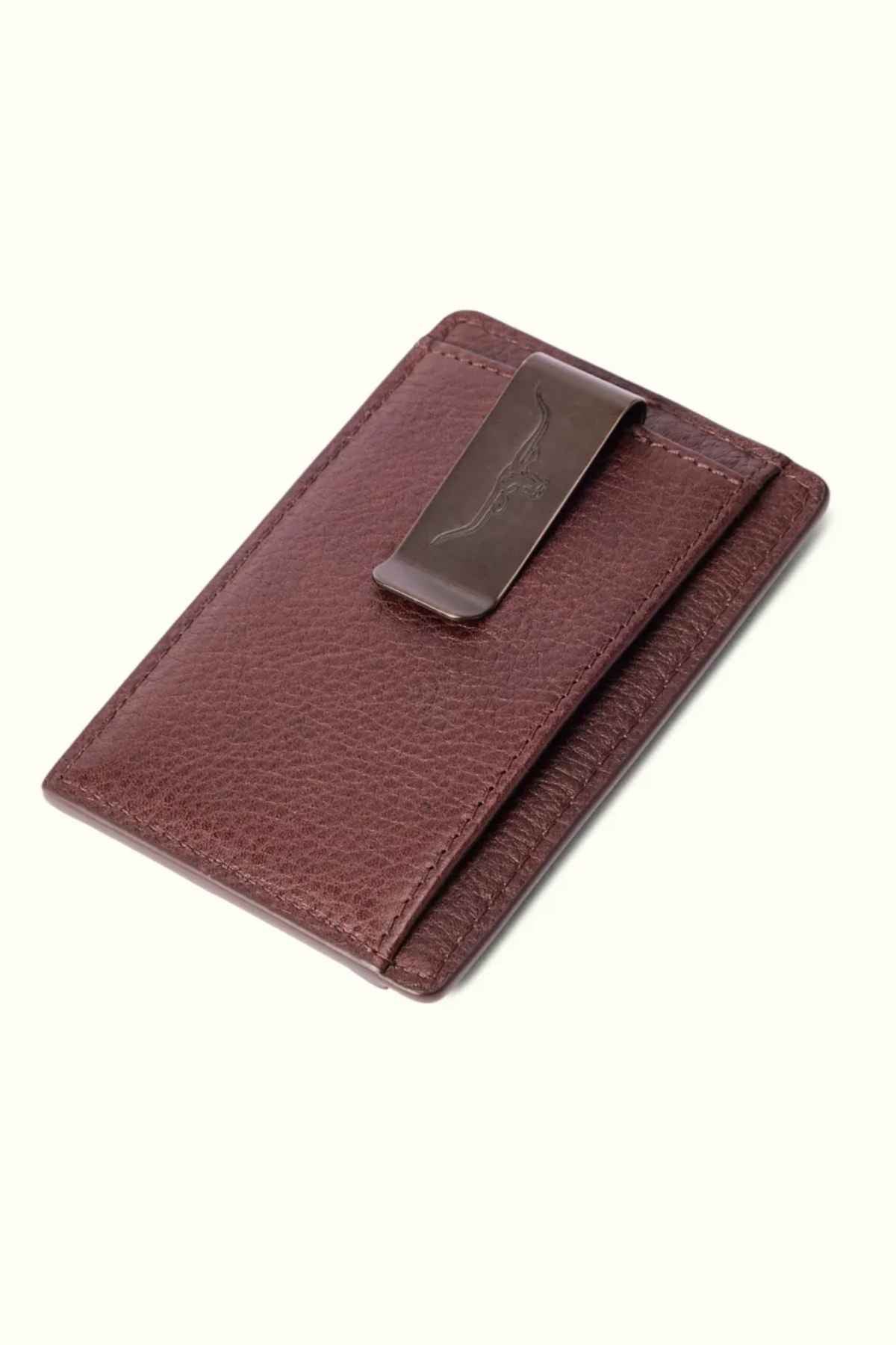 The RM Williams Farrier Cardholder with Money Clip is a premium leather accessory featuring a sleek metal money clip and an embossed feather design. The closed brown cardholder rests elegantly against a neutral background.