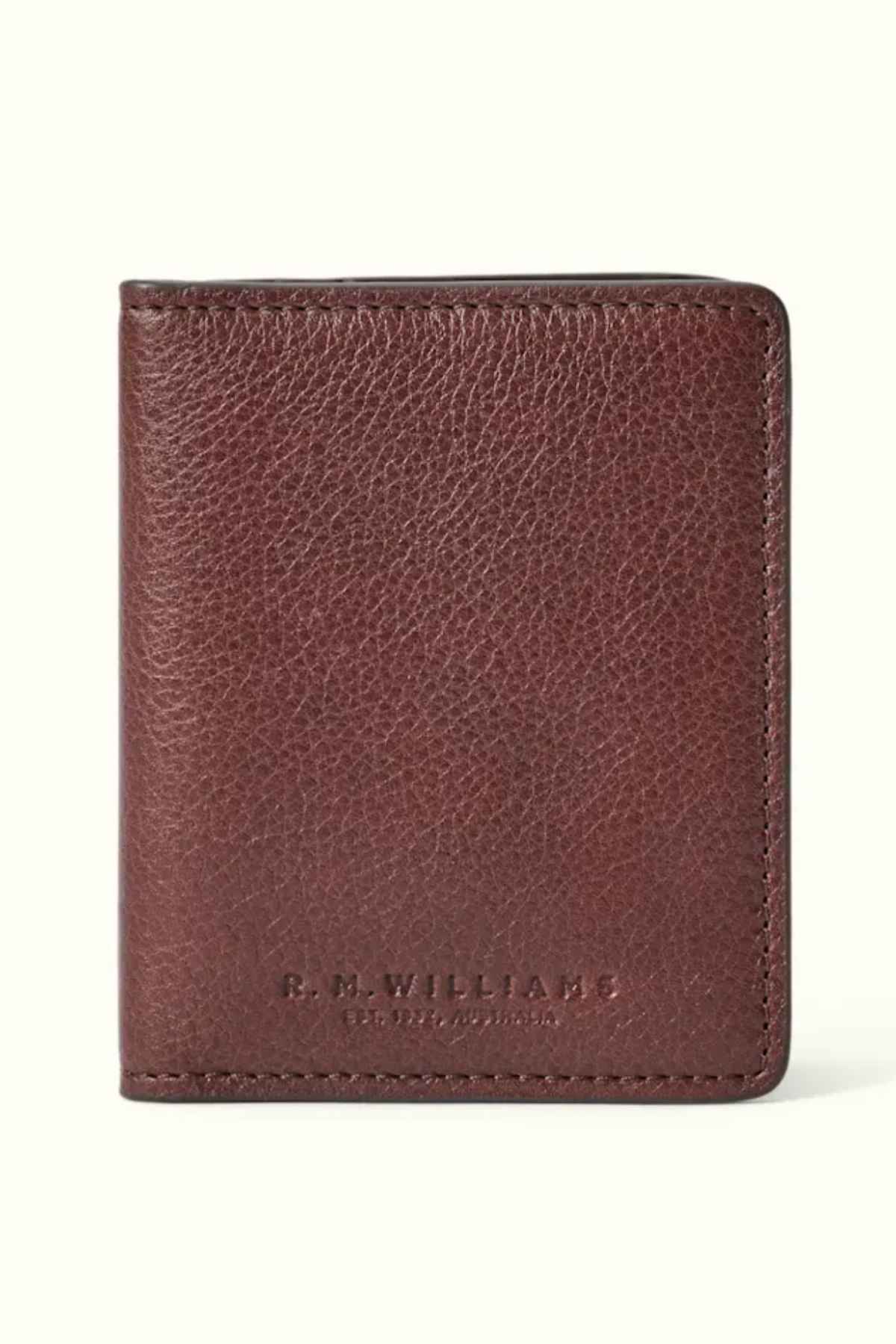 The RM Williams Farrier Fold Cardholder, crafted from premium brown leather and embossed with "R.M. Williams" and "Est. 1932 Australia" on the front, features a textured appearance against a light background. It provides ample card slots for optimal organization.