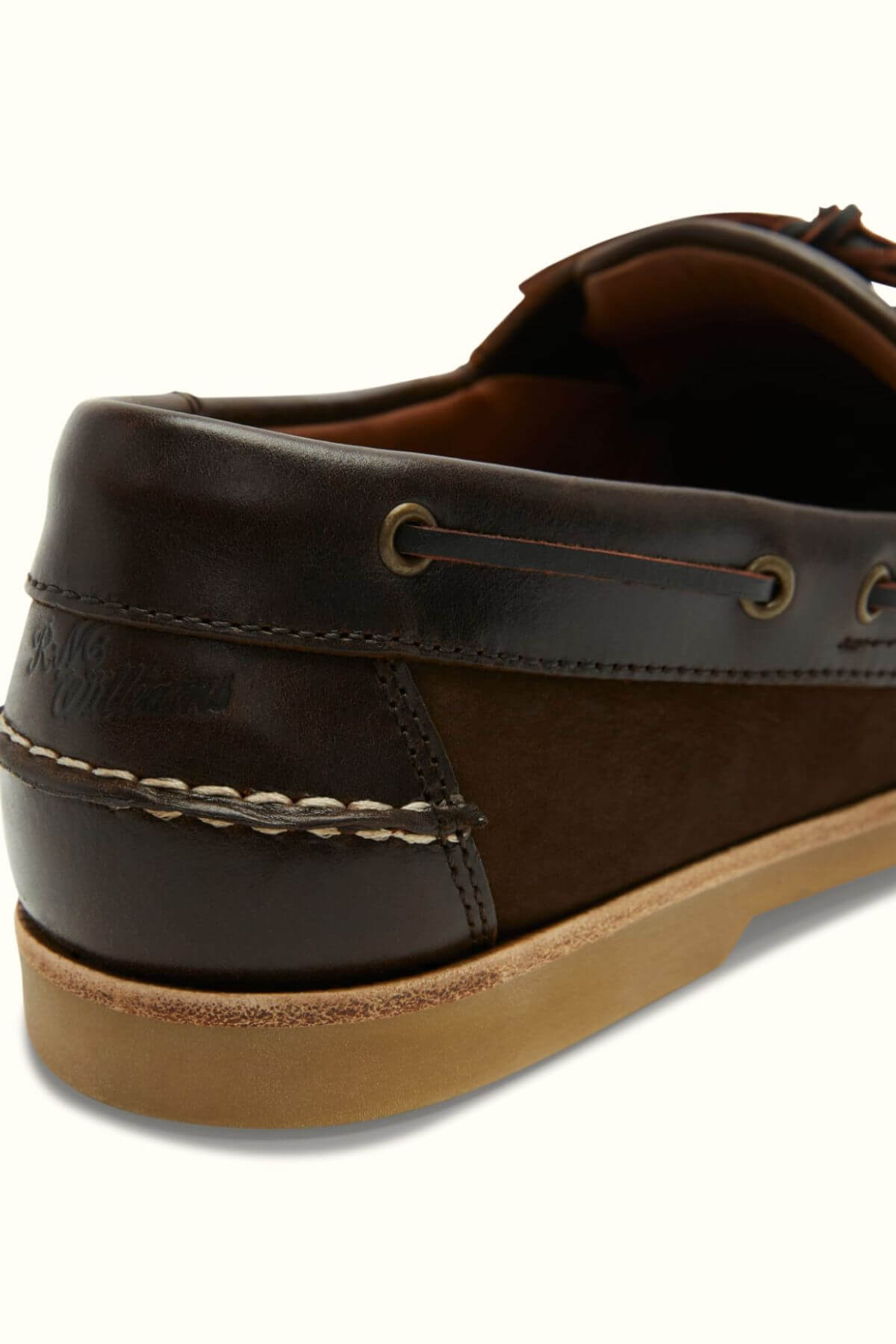 Close-up view of the back and side of the RM Williams Hobart Boat Shoe in brown bovine leather, featuring moccasin construction, tan stitching, leather lacing, a light brown rubber sole, and an embossed brand logo on the heel.
