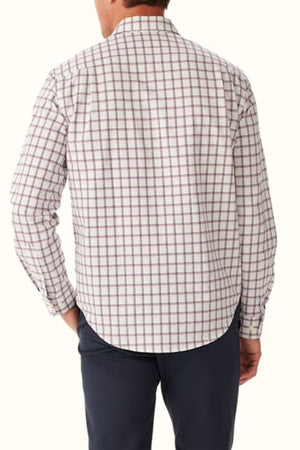 A man faces away, wearing the RM Williams Classic Twill Check Shirt—premium cotton in a red and blue check—paired with dark pants. His right hand rests in his pocket.