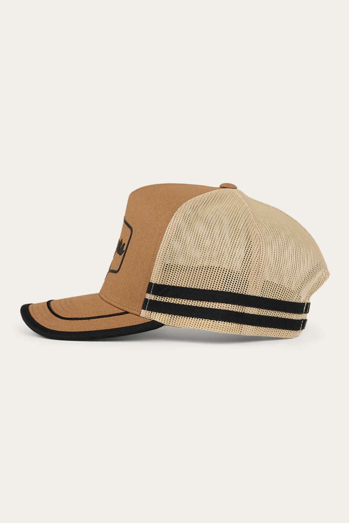 A side view of the Ringers Western Cobar Trucker Cap showcases a brown and beige design with a flat brim. The front panel and brim are solid brown, adorned with a black emblem, while the mesh back is beige, featuring two black horizontal stripes. This cap has a structured crown and includes an internal sweatband for added comfort.