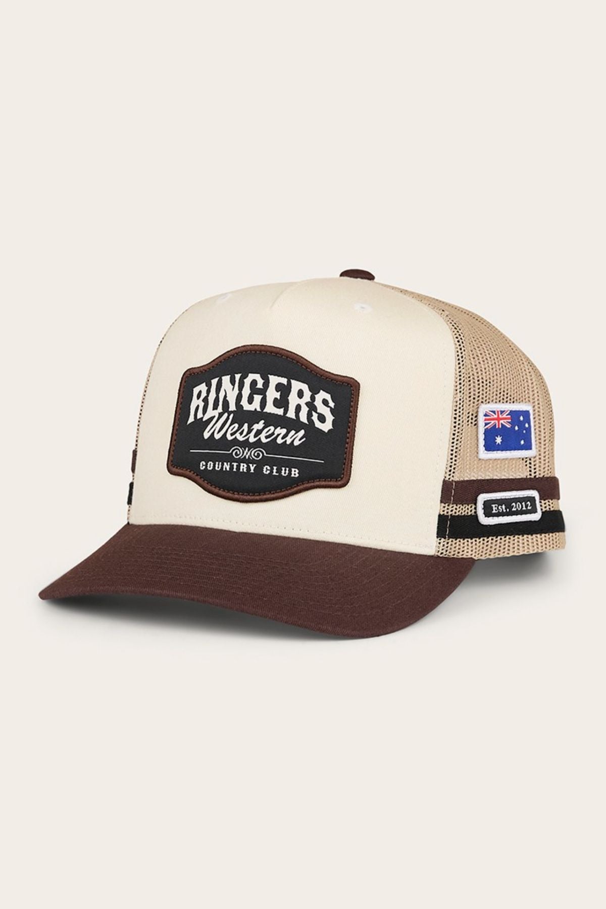 The Ringers Western Country Club Deep Fit Trucker Cap features a beige and brown design, a front "Ringers Western Country Club" patch, side mesh panel with "Est. 2012," a small Australian flag patch, and classic deep fit styling.