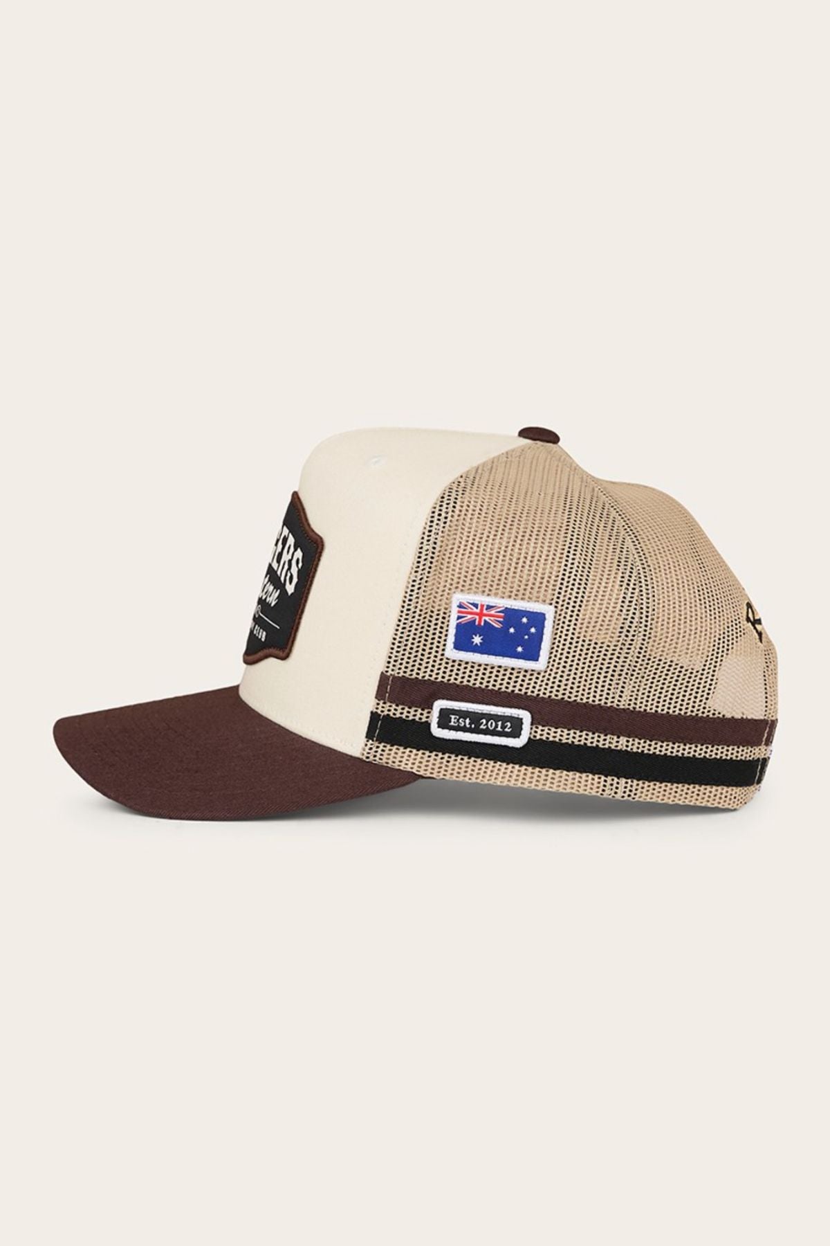 The Ringers Western Country Club Deep Fit Trucker Cap features a beige and brown country style, mesh back, brown brim, embroidered Australian flag patch, "Est. 2012" side label, and an adjustable snapback for perfect fit.