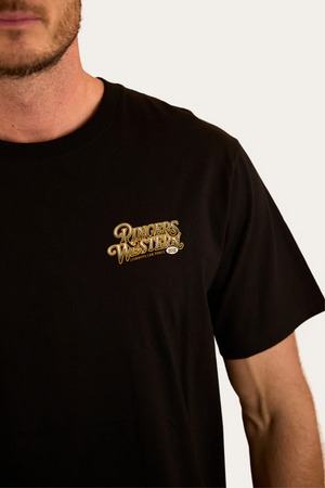 A man models the Ringers Western Cowboys Can Dance Loose Fit T-Shirt, featuring a yellow logo on the left chest. Only his lower face and upper torso appear against a plain background, showcasing classic Cowboys Can Dance style.