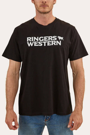A man is wearing a Ringers Western Hastings Loose Fit T-Shirt in black, made from 100% cotton jersey. The shirt features the text "RINGERS WESTERN" and an illustration of a bucking horse printed in white on the chest. He is standing against a plain background and is also sporting blue jeans.