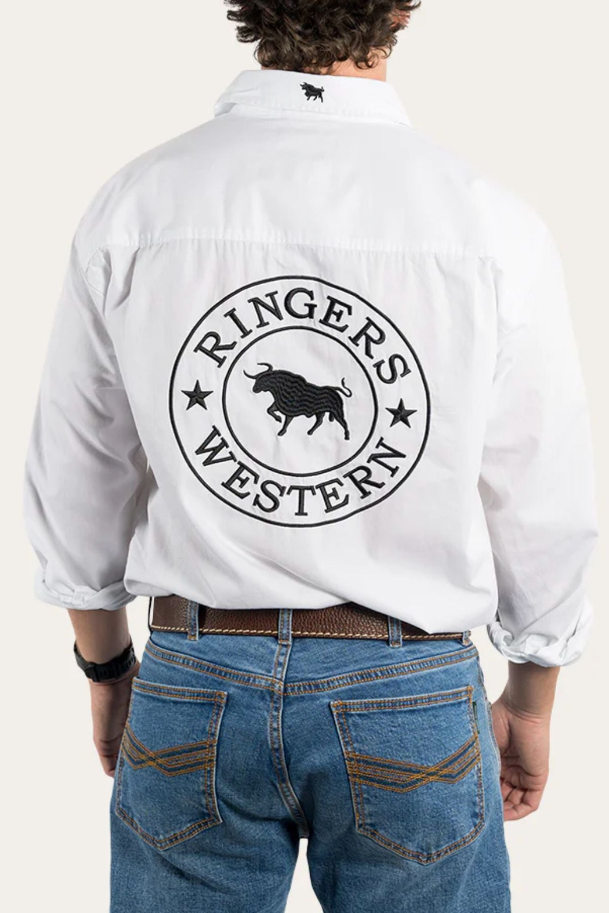 Wearing the Ringers Western Hawkeye Embroidered Shirt in premium cotton with "RINGERS WESTERN" and a bull logo in black on the back, paired with blue jeans and a brown belt.