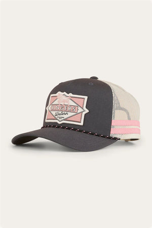The Ringers Western Hometown Trucker Cap features black and white panels, a pink and white front patch, pink trim on the brim, pink stripes on the mesh back, and an adjustable snapback for a comfortable fit.