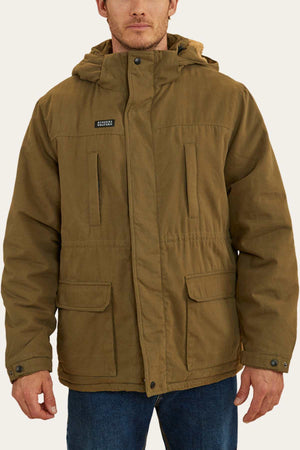 A person is wearing the Ringers Western Judd Jacket, which is brown, hooded, and insulated with sherpa lining. The jacket features a zip and button closure, two chest pockets, and two large front pockets with flaps. The person is also wearing blue jeans against a plain off-white background.