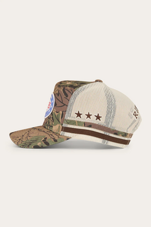 The Ringers Western Shooter Deep Fit Trucker Cap features a camouflage front, beige mesh back, brown star side detail, circular blue/red front patch, brown text on the mesh, and an adjustable snapback for a perfect fit.