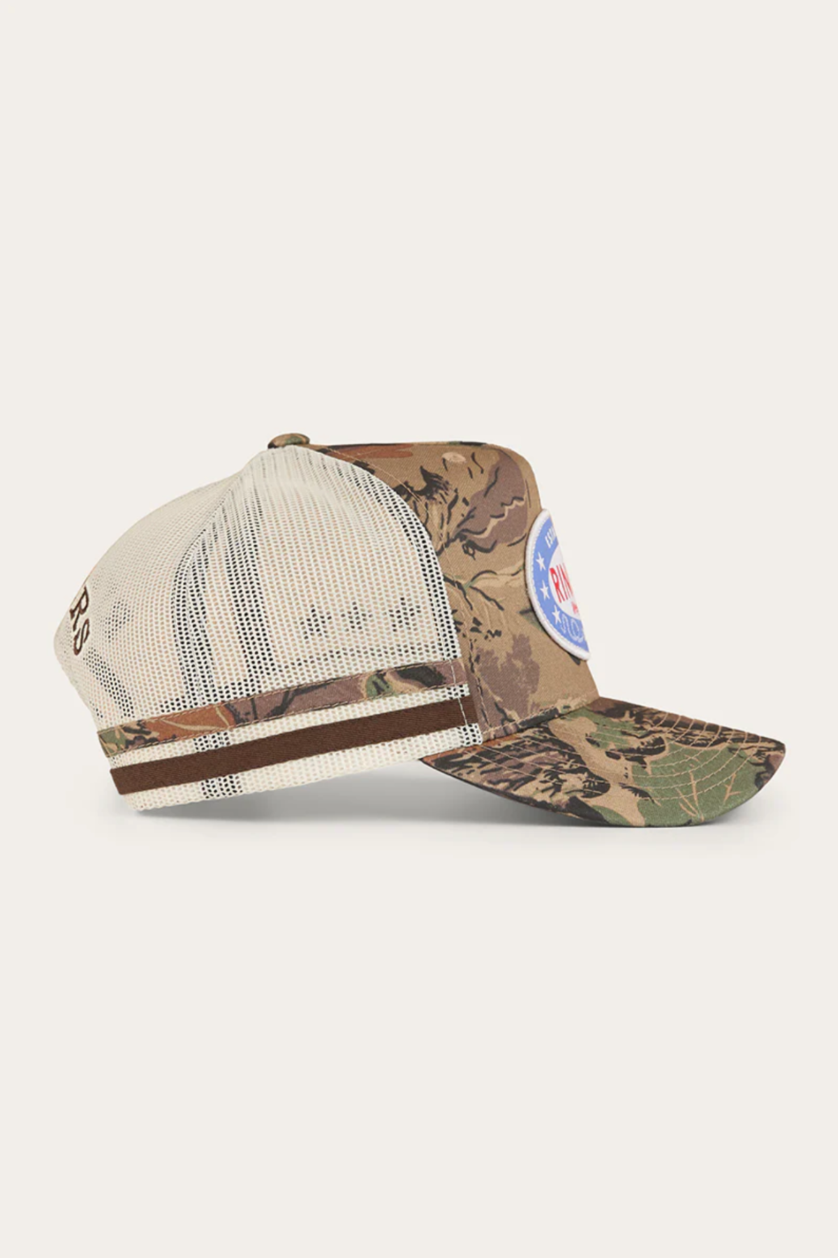 The Ringers Western Shooter Deep Fit Trucker Cap features a beige mesh back, brown and green camo front, side stripes, a blue and white patch on the front, and an adjustable snapback for comfort.
