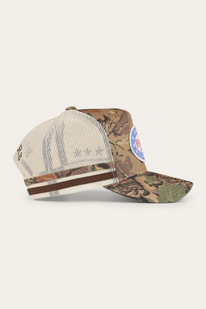 The Ringers Western Shooter Deep Fit Trucker Cap features a beige mesh back, brown and green camo front, side stripes, a blue and white patch on the front, and an adjustable snapback for comfort.