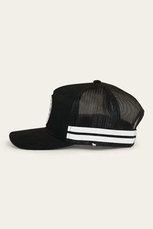 A side view of the Ringers Western Signature Bull Flag Trucker Cap, showcasing its black mesh design and curved brim. The cap features two white horizontal stripes on the side panel and a small logo near the base. Partially visible on the front panel is a circular patch. For an adjustable fit, this stylish hat comes equipped with a snapback closure.