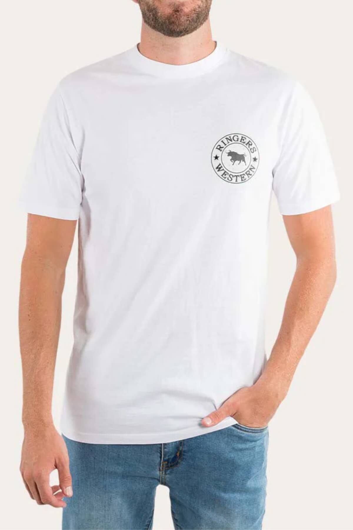 A person wears the Ringers Western Signature Bull Loose Fit T-Shirt, made of 100% Cotton Jersey. The white tee features the logo—a circular design with text and a bull—on the left chest. Paired with blue jeans, they stand against a plain background.