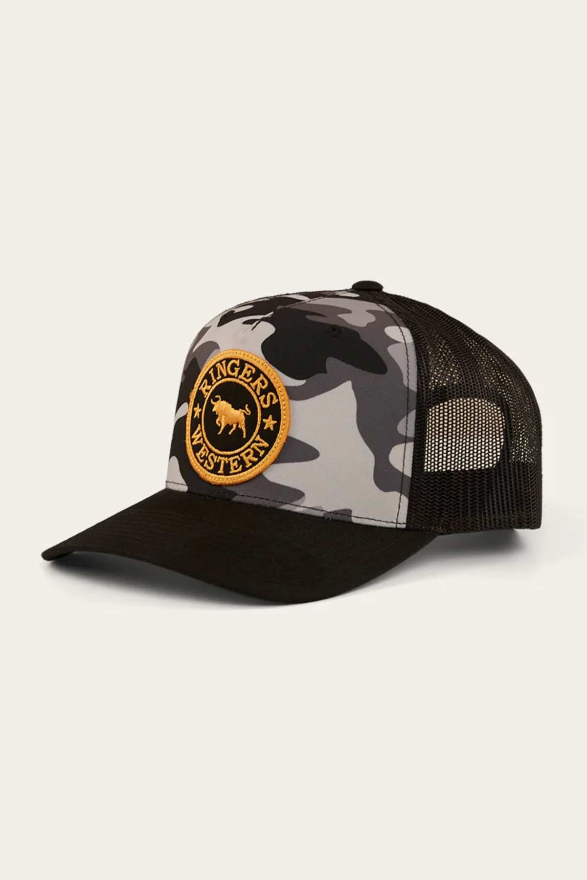 The Ringers Western Signature Bull Trucker Cap has a camouflage pattern, a black brim, and a breathable mesh back. It features a circular yellow patch on the front with "Ringers Western" and a bull silhouette in the center.