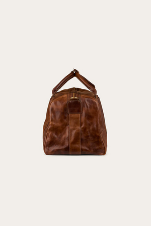 The Ringers Western Toro Gino Overniter is displayed upright, viewed from the front with its handles together at the top and a visible buckle detail. The bag features a soft, slightly worn full grain leather texture.
