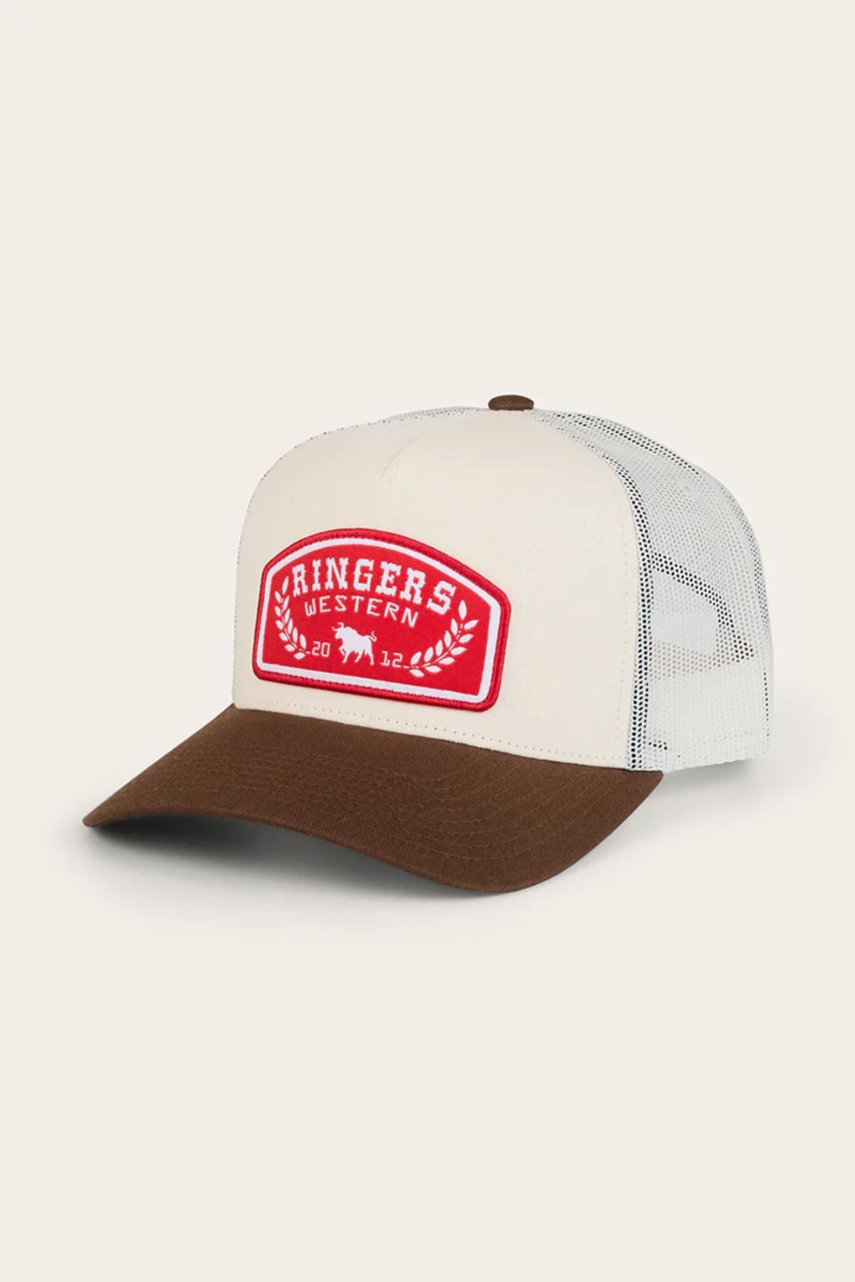 The Ringers Western Wheatbelt Trucker Cap features a white front, brown brim, mesh back, and a red patch with "Ringers Western" and laurel leaves embroidered in white on the front.