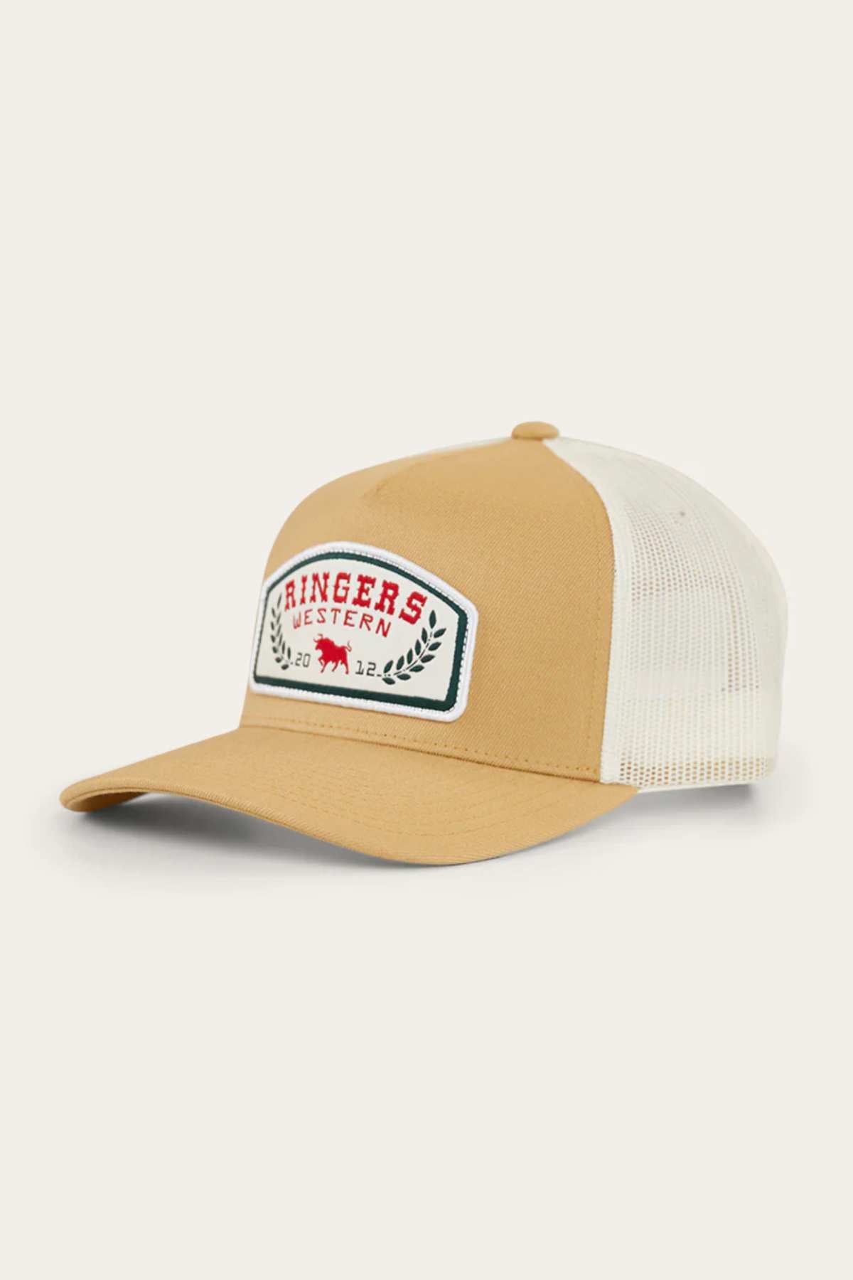 The Ringers Western Wheatbelt Wool Trucker Cap is tan and white with a curved brim, mesh back, adjustable strap, and a front patch that displays “Ringers Western 2022” in red text with a red bull and green laurel wreaths.