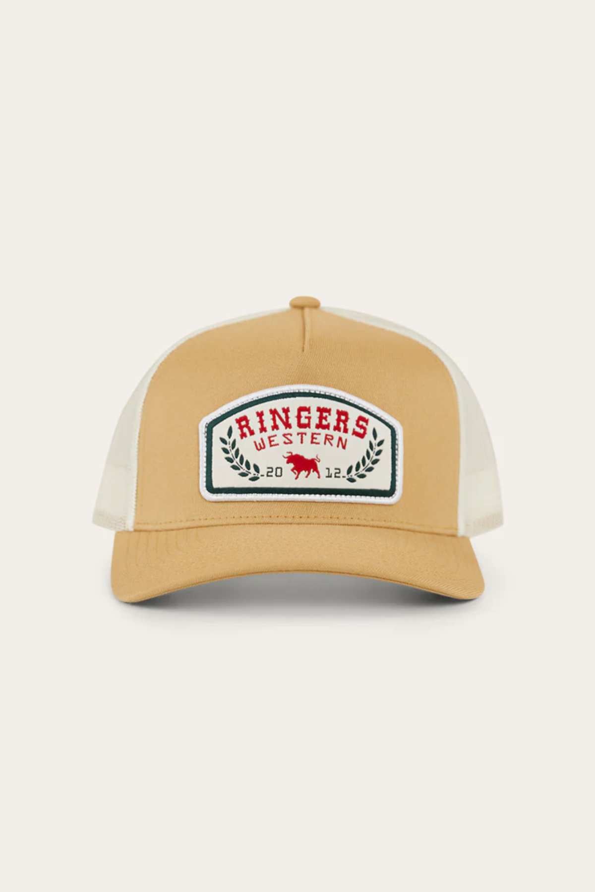 The Ringers Western Wheatbelt Wool Trucker Cap features a tan and white design, mesh back, adjustable strap, and a front patch with "Ringers Western" in red above a red bull and laurel leaves.