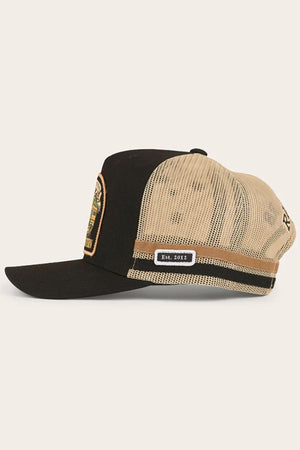 The Ringers Western Workhorse Trucker Cap features a black and beige design, mesh back, curved brim, adjustable snapback, side patch reading "Est. 2012," and a colorful embroidered patch on the front for style and function.