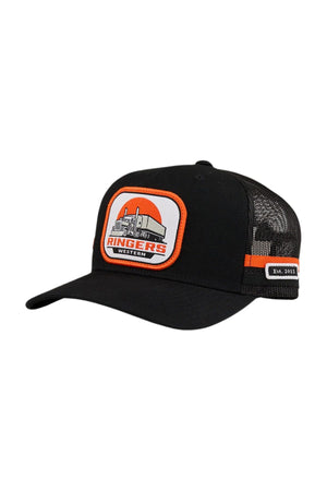 The Ringers Western Big Rig Trucker Cap features black mesh, an adjustable snapback, an orange and white semi-truck patch with "RINGERS WESTERN," orange side stripe, and a small "Est. 2012" label on its deep-fit design.
