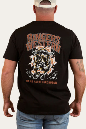 A man stands with his back to the camera wearing a Ringers Western Do No Harm Take No Bull Loose Fit T-Shirt, featuring a bull graphic and the slogans "Ringers Western" and "Do No Harm, Take No Bull" on the back.