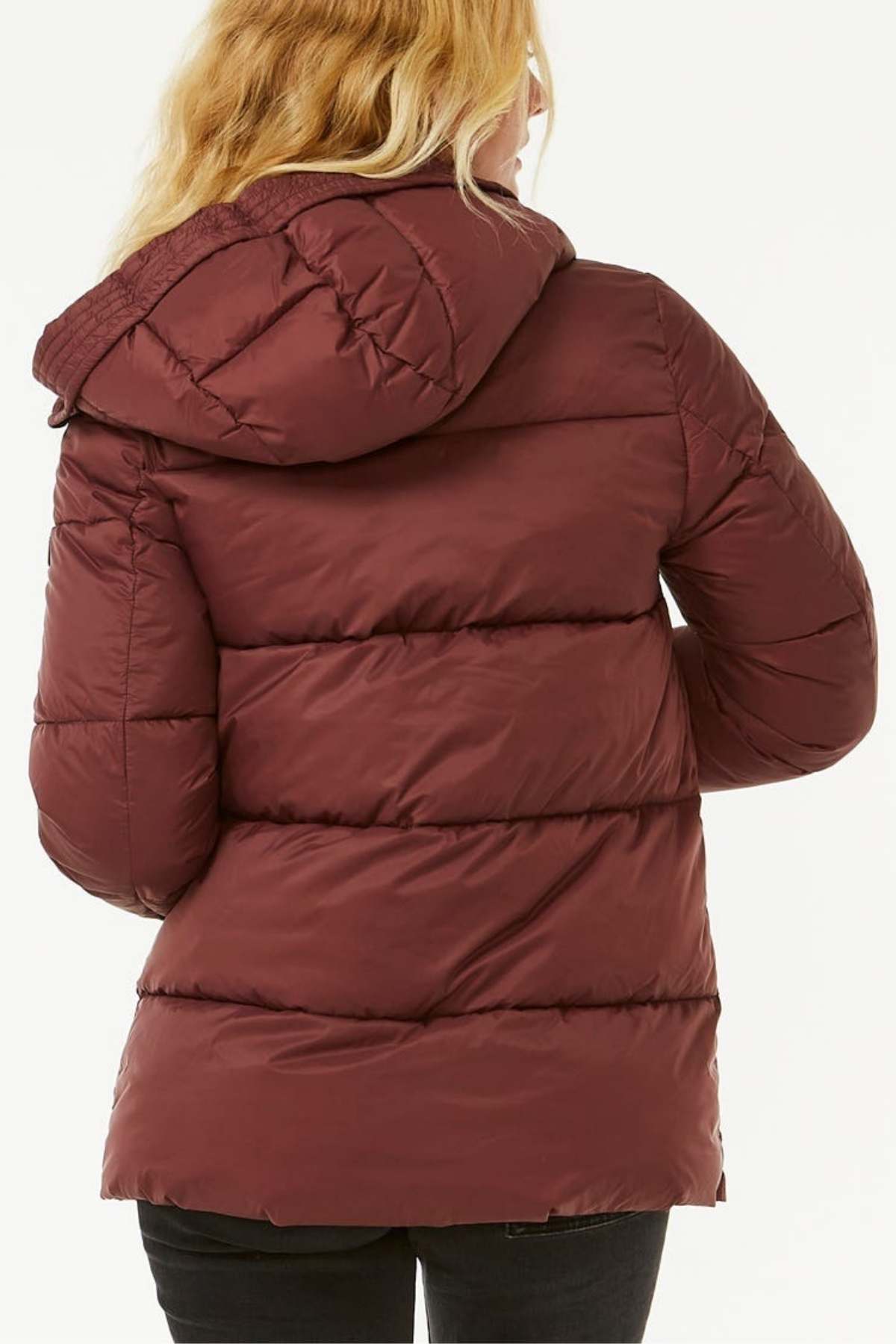 A woman with long blonde hair is seen from behind wearing a maroon Rip Curl Anti Series Insulated Jacket. The jacket has a hood, a quilted design, and DWR water repellent treatment. She is also wearing dark pants, standing against a plain white background.
