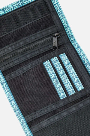 The Rip Curl Archive Cord Surf Wallet in black corduroy features blue geometric trim, multiple card slots with decorative blue edging, and a zippered compartment. The wallet is open, displaying its stylish interior design.