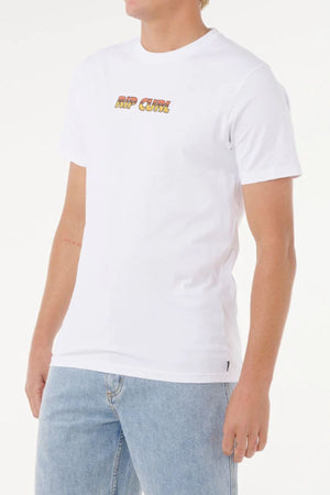 A person wears the Rip Curl Big Mumma Icon Tee, made from organic cotton and featuring colorful chest lettering, paired with light blue jeans. The casual look stands out on a white background, with the face partially out of view.