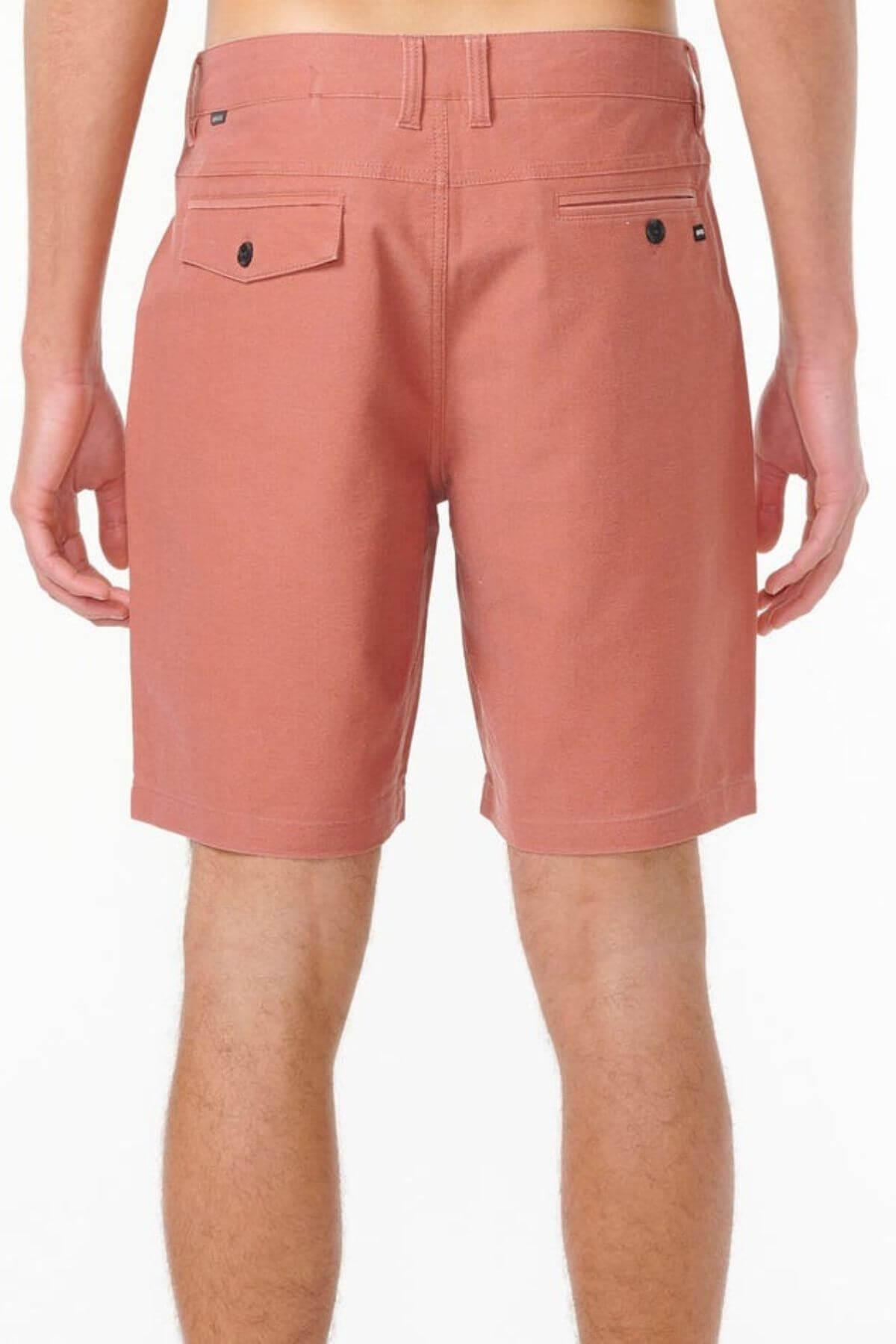 A person is shown from the waist down, wearing Rip Curl Boardwalk Epic Mix shorts in salmon, featuring quick-dry fabric, belt loops, and two back pockets—one with a button—set against a plain white background.
