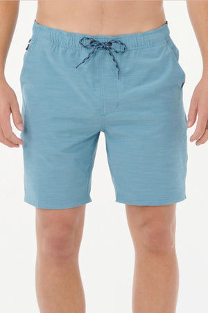 A person wearing light blue Rip Curl Boardwalk Jackson Volley shorts, shown from waist to just above the knees, with hands by their sides against a plain white background.