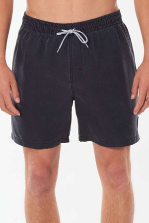 A person wearing Rip Curl Bondi Volley shorts in black stands against a plain background. These sustainable shorts, made from recycled PET, feature an elastic waistband with a white drawstring. The shot captures the individual from the waist to the knees.