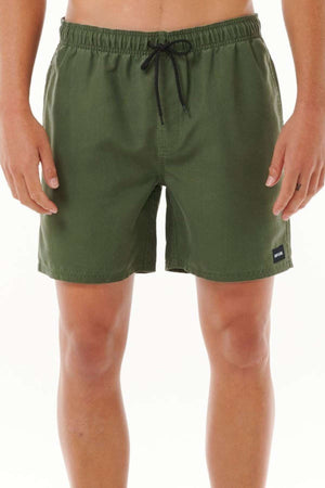 A person wearing Rip Curl Bondi Volley shorts in olive green with a black drawstring stands against a plain white background. These board shorts are made from recycled PET and feature a small black logo patch on the bottom of the left leg.