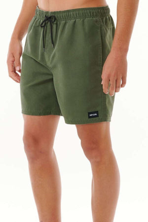 A person wearing olive green Rip Curl Bondi Volley shorts, featuring a black drawstring and a small logo patch on the left leg, crafted from recycled PET, stands against a plain white background.