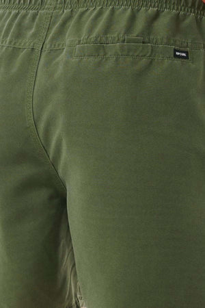 A close-up view of the olive green Rip Curl Bondi Volley pants, highlighting the back pocket area. These pants feature an elastic waistband and a small black label sewn near the pocket edge, made from recycled PET material for an eco-friendly touch.