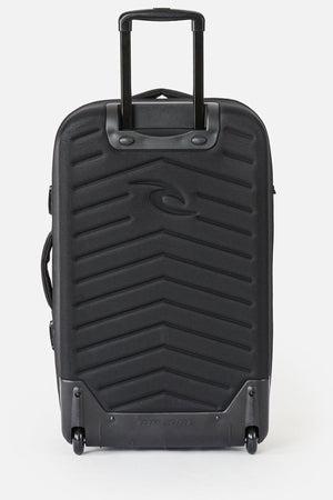 The Rip Curl F-Light Global 100L Bossa Nova is a black rolling suitcase featuring a chevron-textured front, extended telescopic handle, two wheels, and an AirTag sleeve—ideal for tracking your check-in bag on any trip.