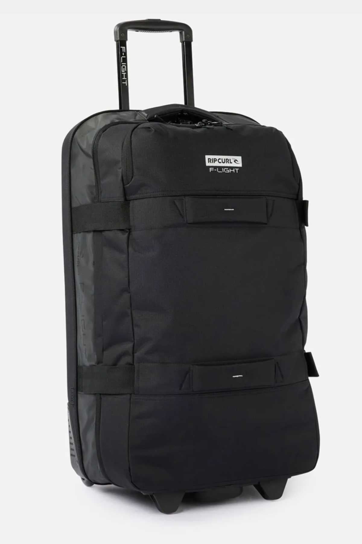 A black Rip Curl F-Light Global 100L Icons Travel Bag with "F-Light" branding. The 100L bag features a telescopic handle, two durable top straps, and multiple compartments. It has a rugged design suitable for travel.