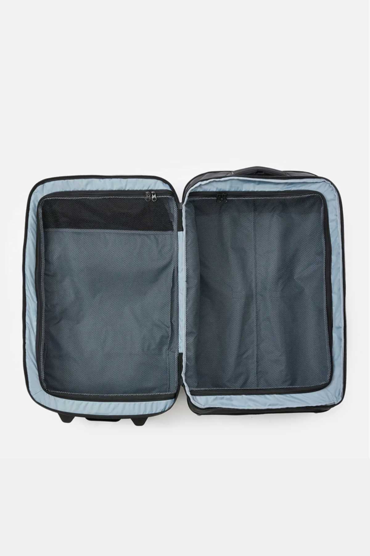 An open Rip Curl F-Light Global 100L Icons Travel Bag in black is displayed against a white background. The suitcase features a grey interior with two large compartments: one secured with a mesh zipper pocket, and the other a plain storage compartment, providing ample space with its 100L capacity.