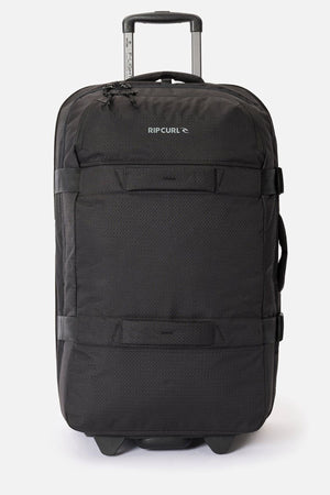 The Rip Curl F-Light Global 100L is a large black check-in suitcase with a telescopic handle, front logo, multiple zippers and straps, plus a built-in AirTag sleeve for easy tracking.