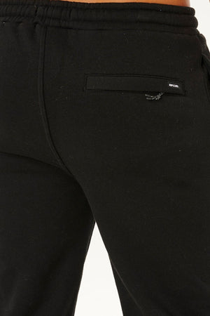 Close-up of the back pocket area of black Rip Curl Icons Of Surf Trackpant, featuring a small Rip Curl logo tag above the pocket. Designed for comfort, these sustainable trackpants combine style with eco-friendly appeal.