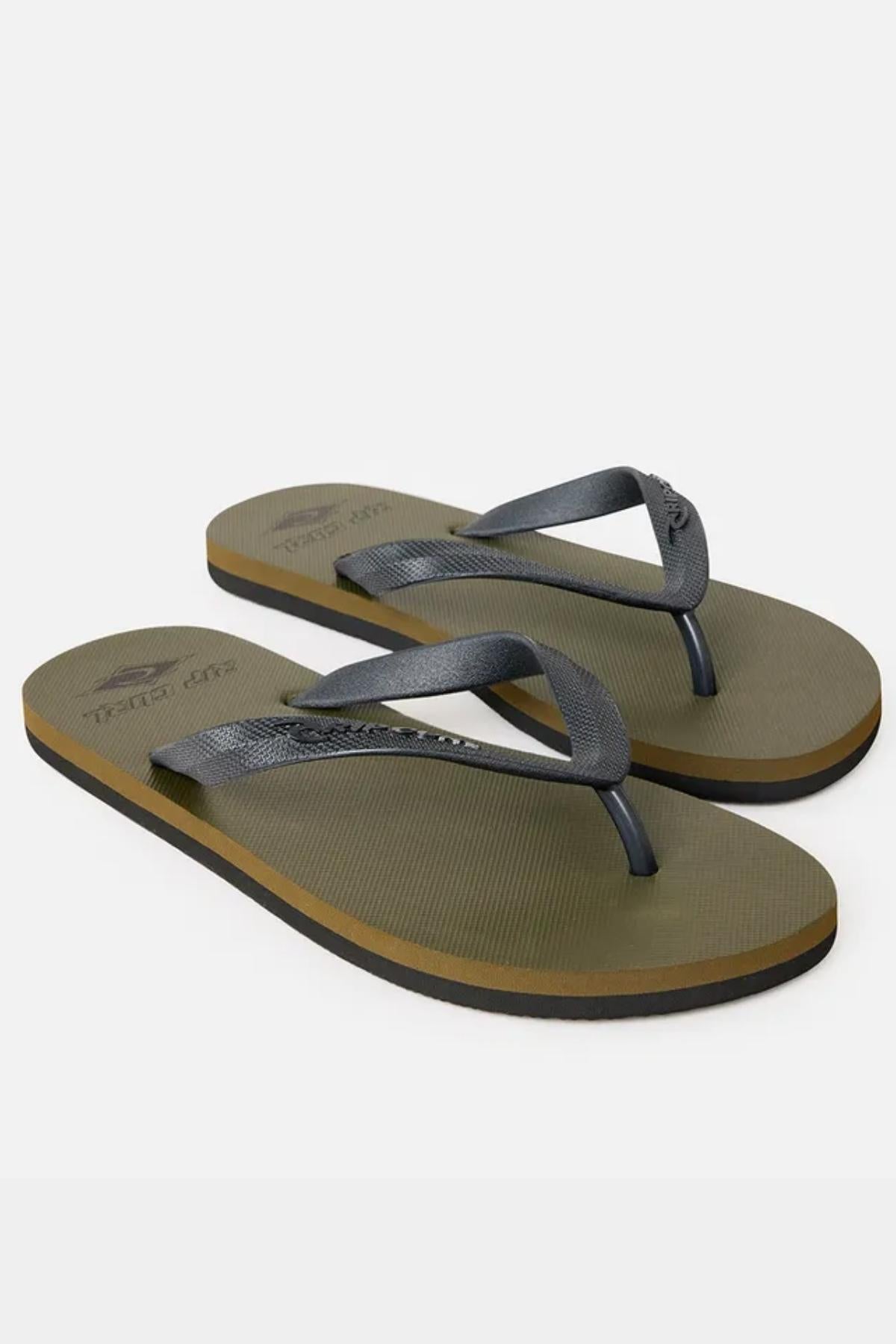 A pair of Rip Curl Icons of Surf Bloom Thongs featuring an olive green hue with black straps and black soles. These flip-flops boast a simple, minimalist design and are displayed on a plain white background.