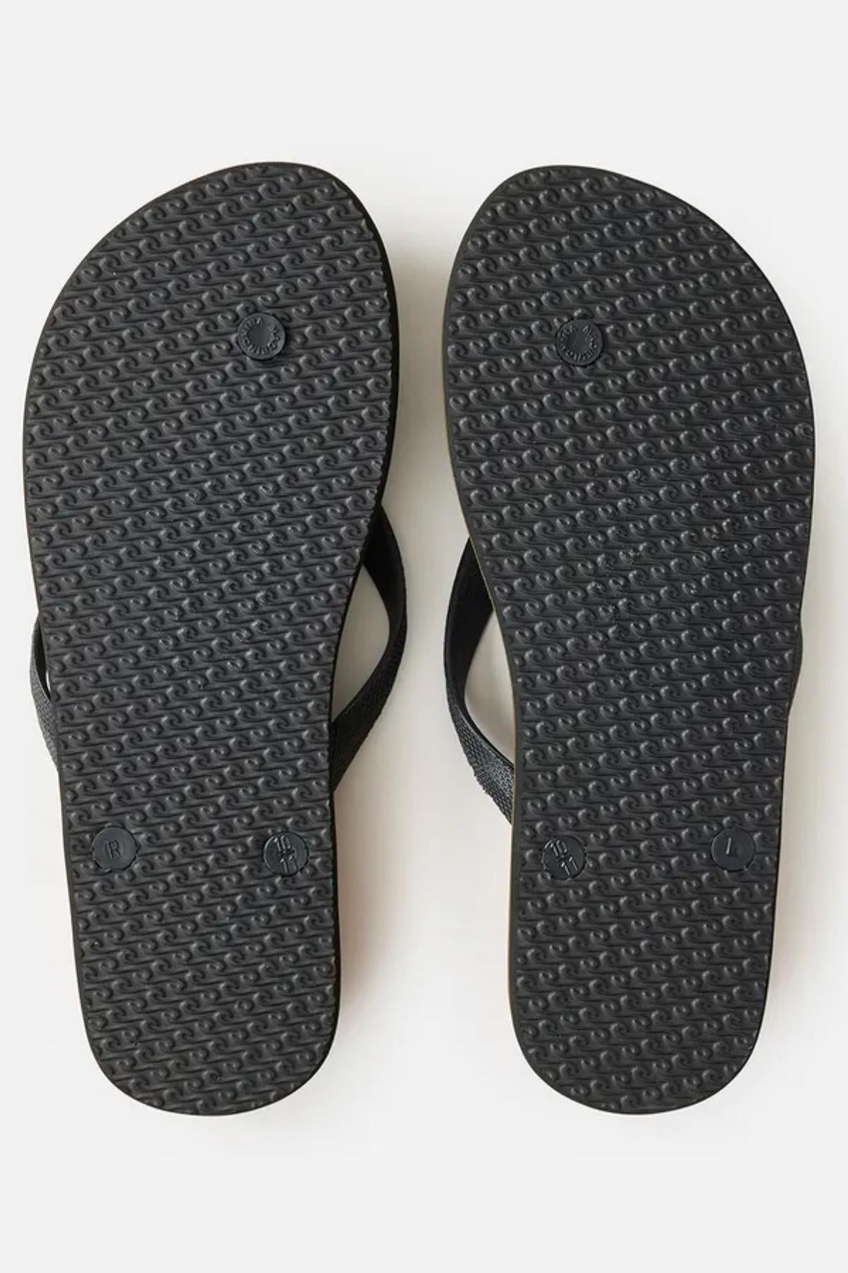 The image shows the soles of a pair of Rip Curl Icons of Surf Bloom Thongs, placed side by side on a plain white background. The soles feature a textured pattern for grip and three small circular imprints evenly distributed along the length of each sole.